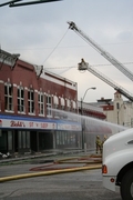 two fire trucks with ladders extended work building fire at Lichti's