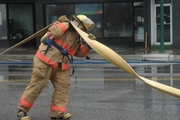 firefighter moving water hose