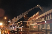 fire trucks working to put out blaze at night